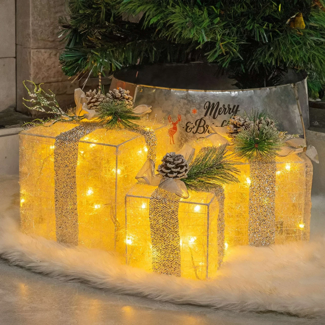 Golden Gleam Gift Box Set with three illuminated gold boxes, bows, and pinecone accents